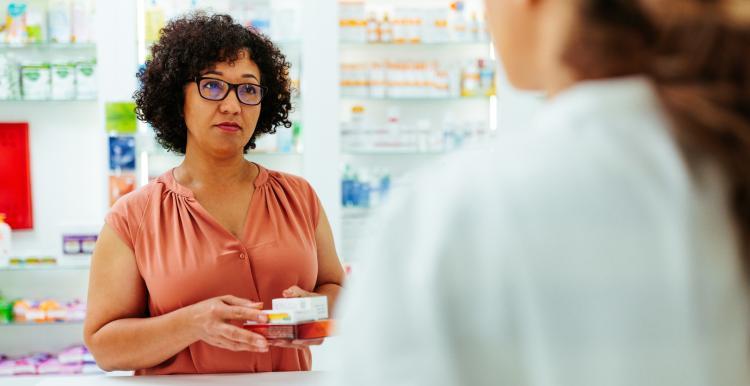 women holding her prescription medication in a pharmacy