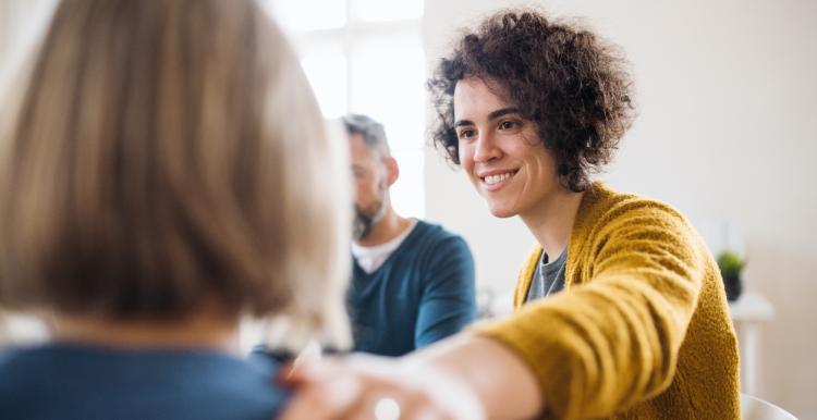 Woman supporting another woman in a group setting