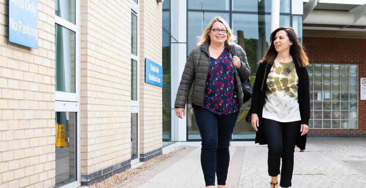 Two women walking outside a hospital