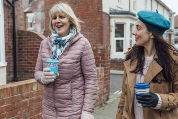 Two women walking down a street